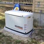 A white generator sitting outside of a house.