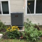 A large air conditioner sitting outside of a house.