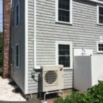 A house with a small air conditioner on the side of it.